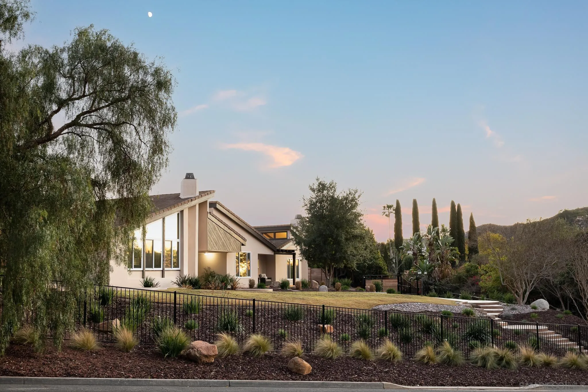 a front view of a house with a yard and trees