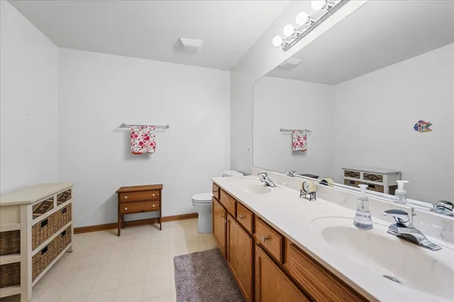 a bathroom with a double vanity sink a mirror and a bathtub