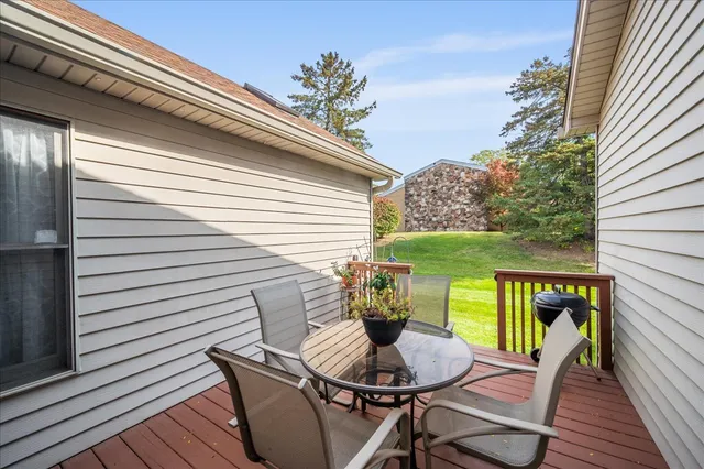 a balcony with table and chairs potted plants with wooden floor
