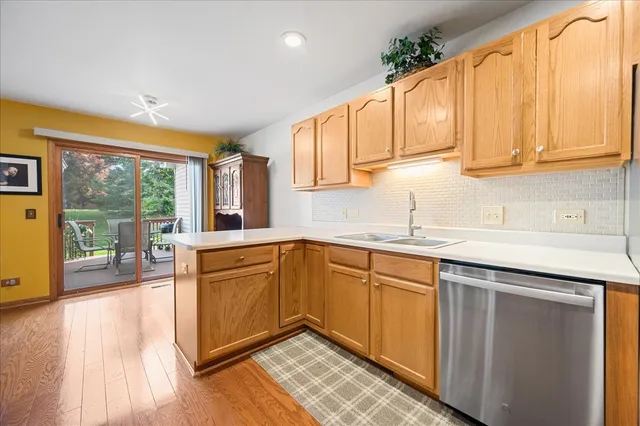 a kitchen with stainless steel appliances granite countertop a sink and cabinets with wooden floor
