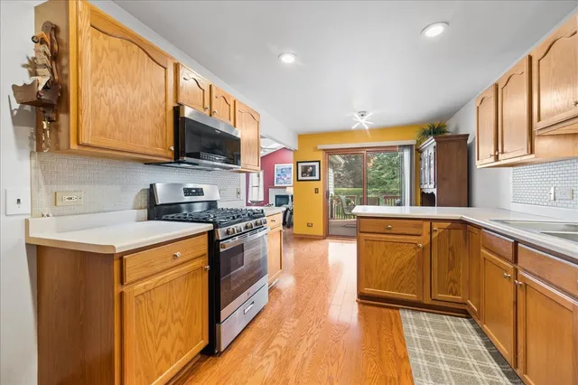 a kitchen with stainless steel appliances granite countertop a stove a sink and a microwave