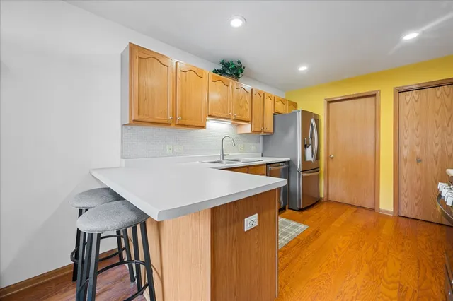 a kitchen with stainless steel appliances a refrigerator a sink a stove a table and chairs