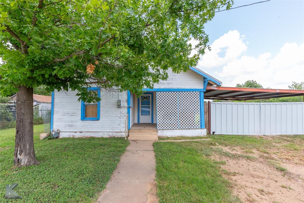 711 South Neches Street Coleman, TX 76834 - Photo 2 of 26 a front view of a house with a yard and garage