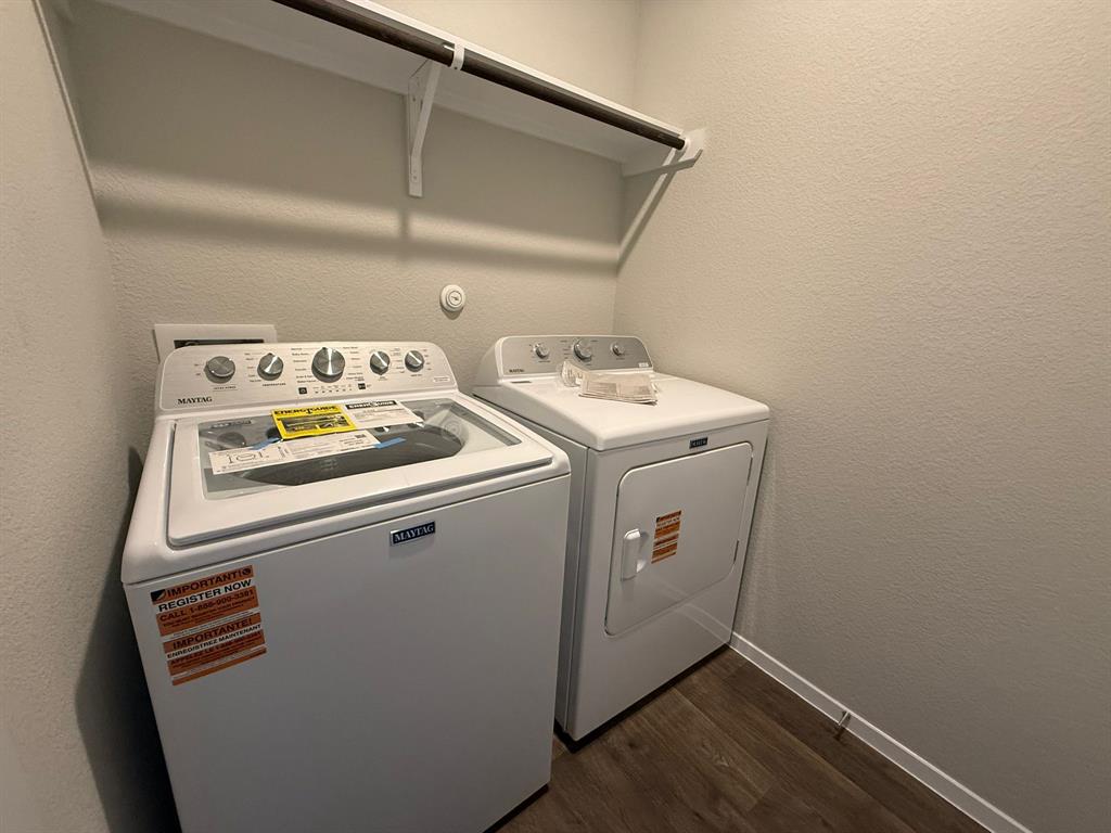 2707 Totley Road Manor, TX 78653 - Photo 12 of 39 Laundry room with a textured wall, washing machine and clothes dryer, and dark wood-type flooring