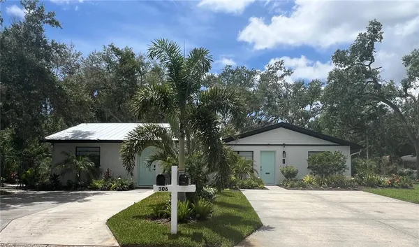 a front view of a house with yard and trees