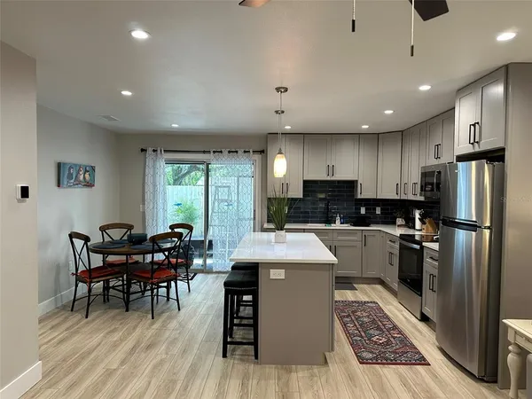 a kitchen with stainless steel appliances kitchen island granite countertop a sink stove and refrigerator