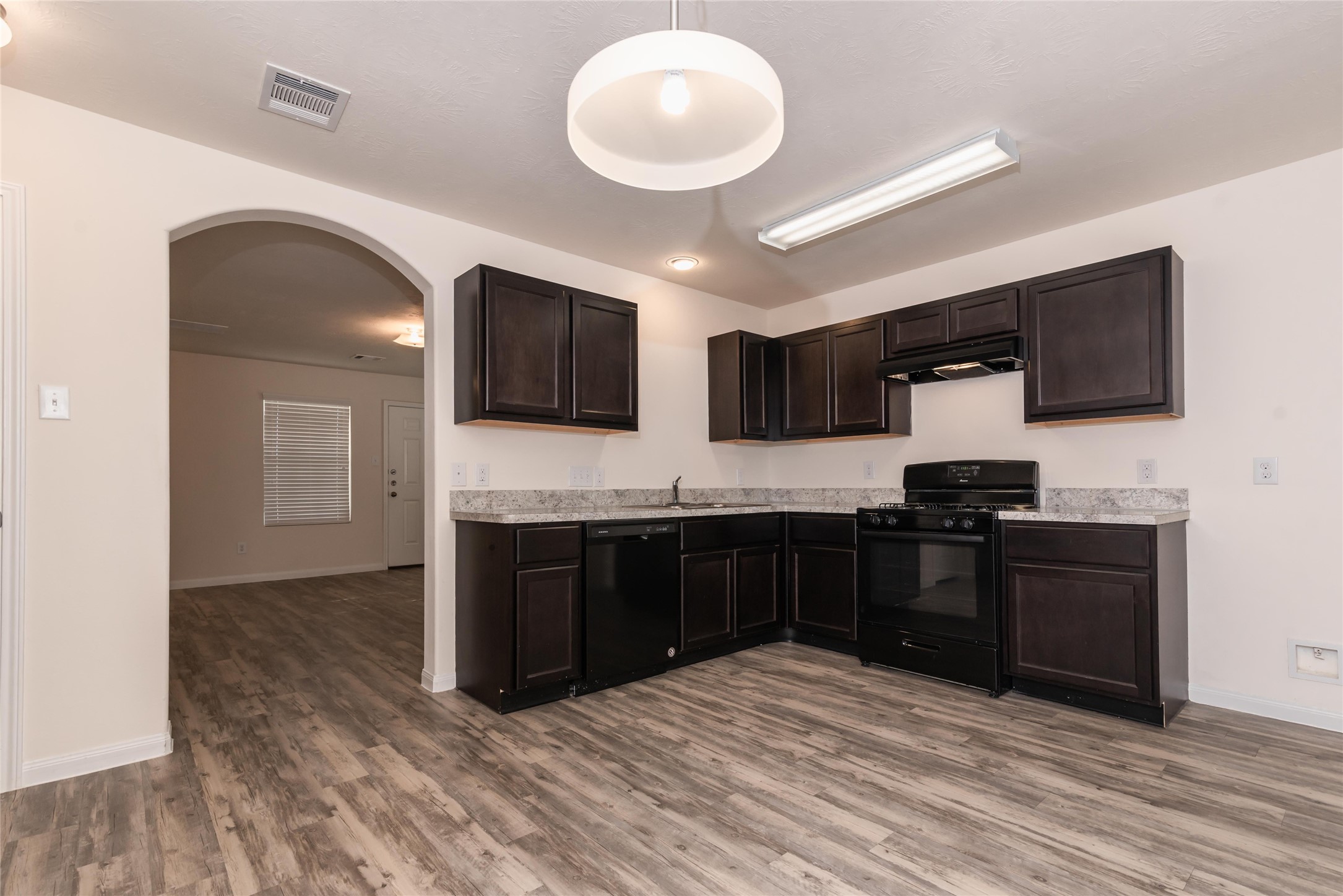 13030 Ristina Circle Houston, TX 77048 - Photo 3 of 10 a kitchen with stainless steel appliances granite countertop a stove top oven a sink dishwasher and a microwave oven on the wooden floor