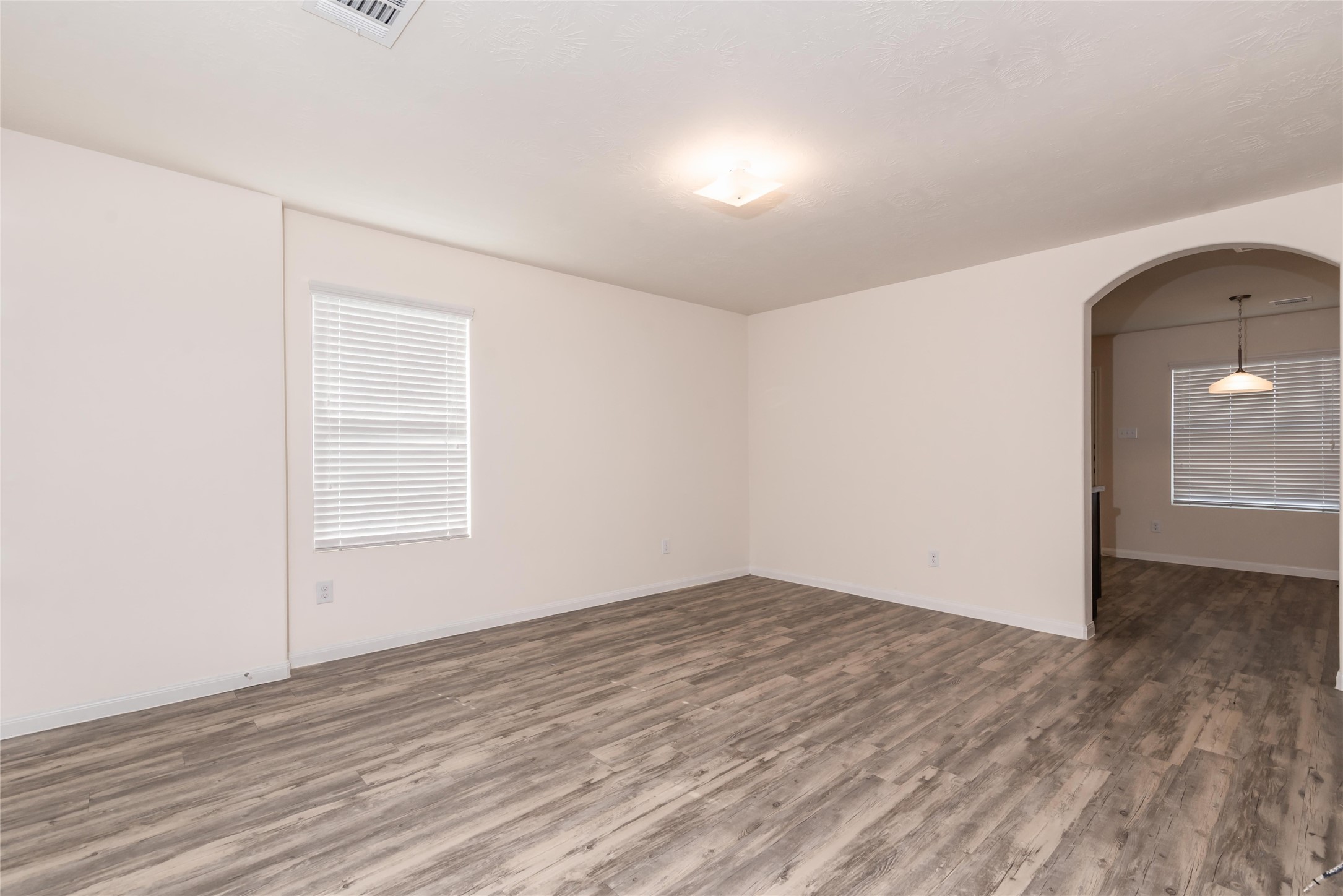 13030 Ristina Circle Houston, TX 77048 - Photo 4 of 10 an empty room with wooden floor and windows