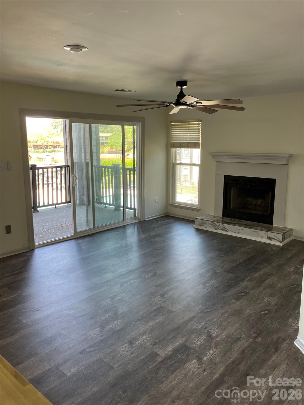 18809 Vineyard Point Lane Cornelius, NC 28031 - Photo 5 of 14 an empty room with wooden floor fireplace and windows