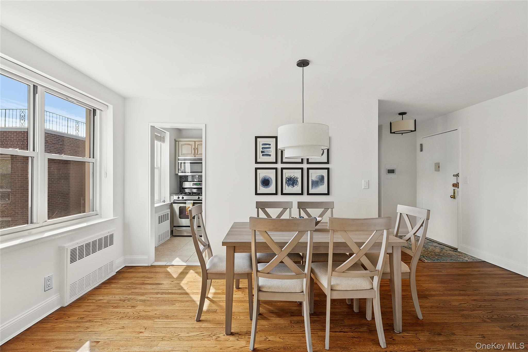 21 Chapel Place, Unit 3M Great Neck, NY 11021 - Photo 6 of 21 Dining area with light wood-type flooring and radiator heating unit