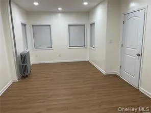 an empty room with wooden floor and a fireplace