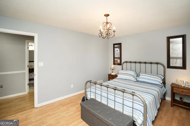 a bedroom with a large bed and a chandelier