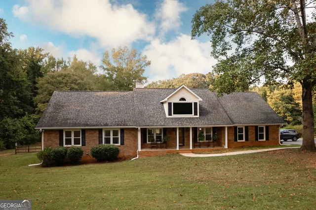 a aerial view of a house next to a big yard and large trees