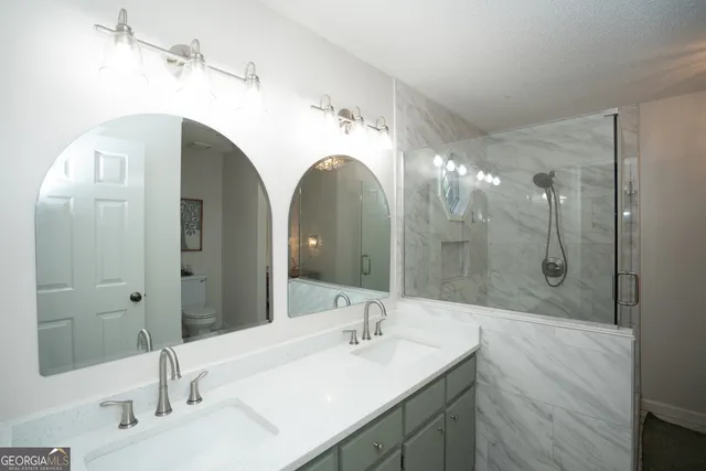 a bathroom with a glass shower door and mirror