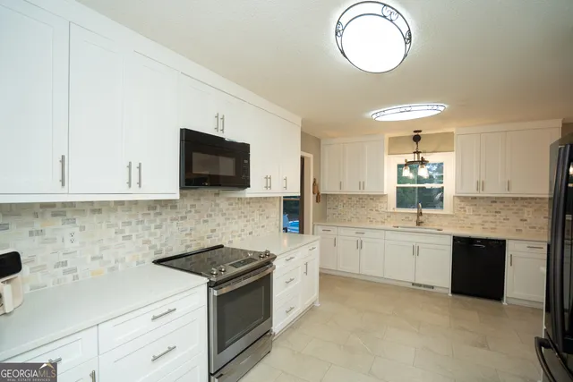 a kitchen with granite countertop a sink stove and cabinets