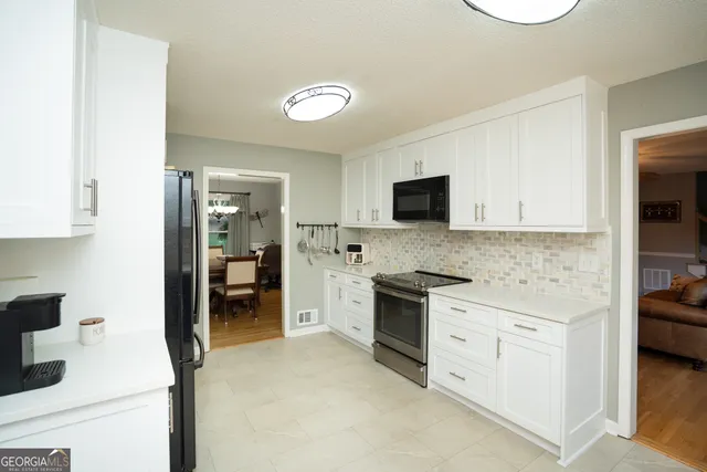 a dining room with wooden floor a chandelier a glass table and chairs