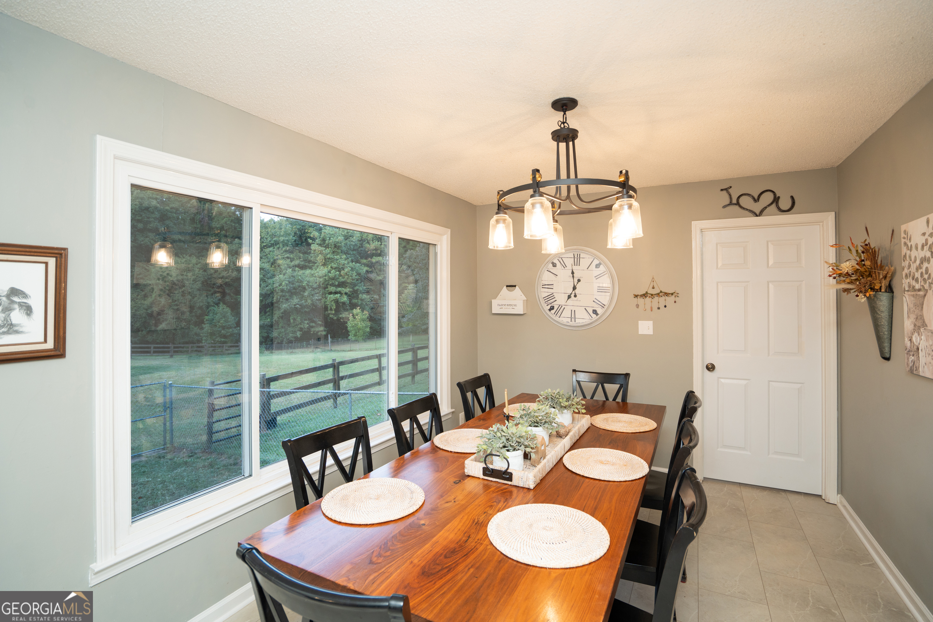 295 Hillview Road Hampton, GA 30228 - Photo 39 of 70 a dining room with wooden floor a chandelier a glass table and chairs