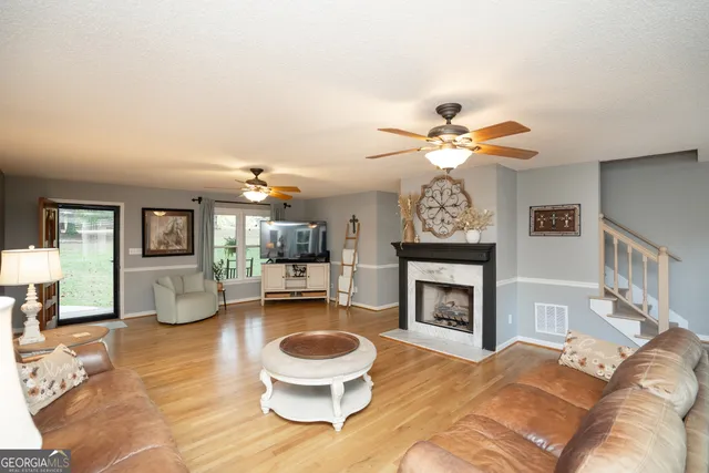 a living room with furniture a flat screen tv and a fireplace