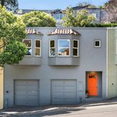 a front view of a house with a tree
