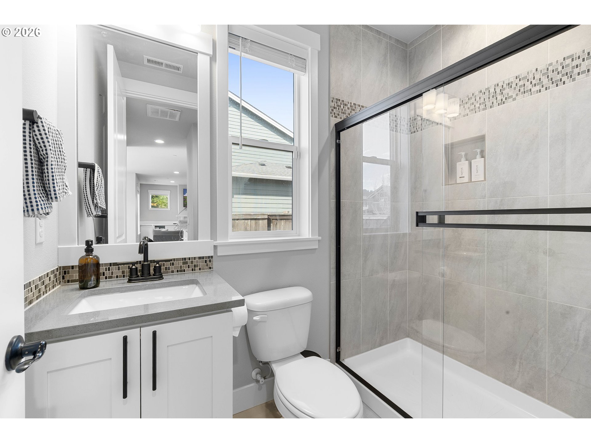 5788 North 86th Circle Camas, WA 98607 - Photo 11 of 26 a bathroom with a sink a toilet a mirror and a shower