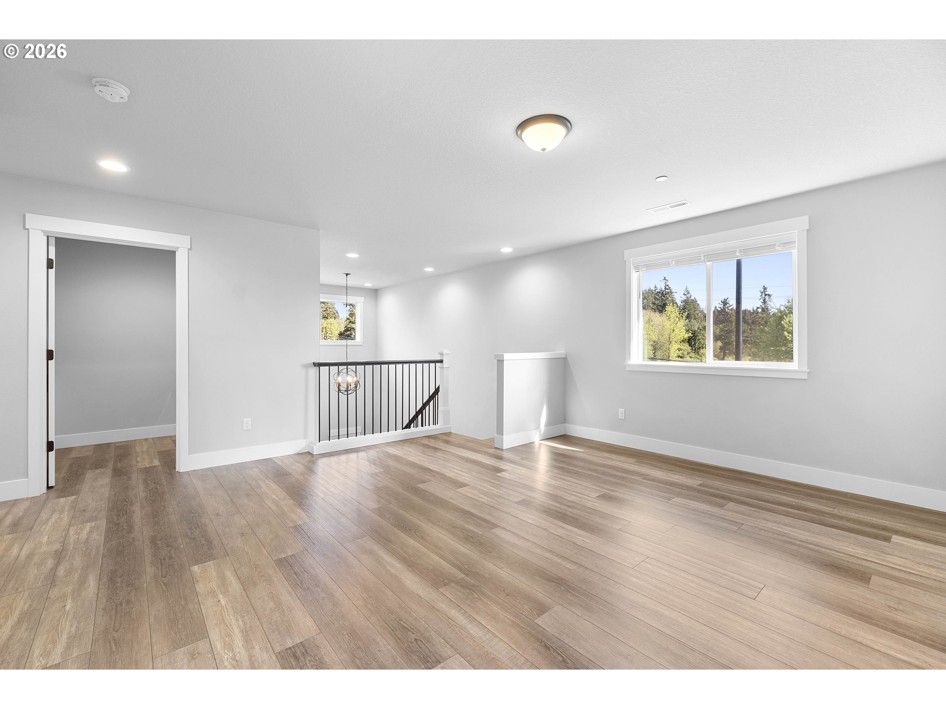 5788 North 86th Circle Camas, WA 98607 - Photo 12 of 26 a view of an empty room with wooden floor and a window