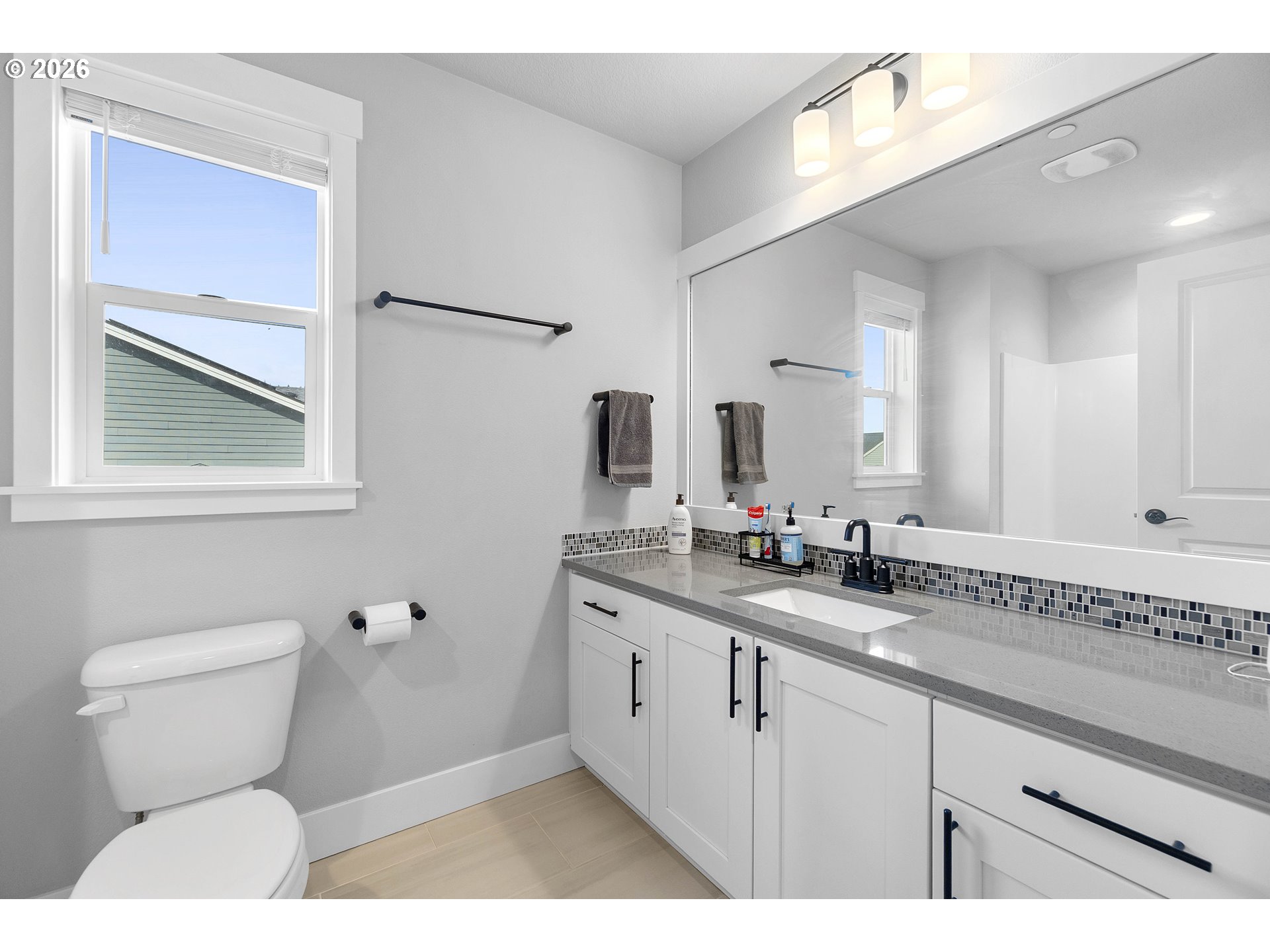 5788 North 86th Circle Camas, WA 98607 - Photo 17 of 26 a bathroom with a granite countertop sink mirror vanity and toilet