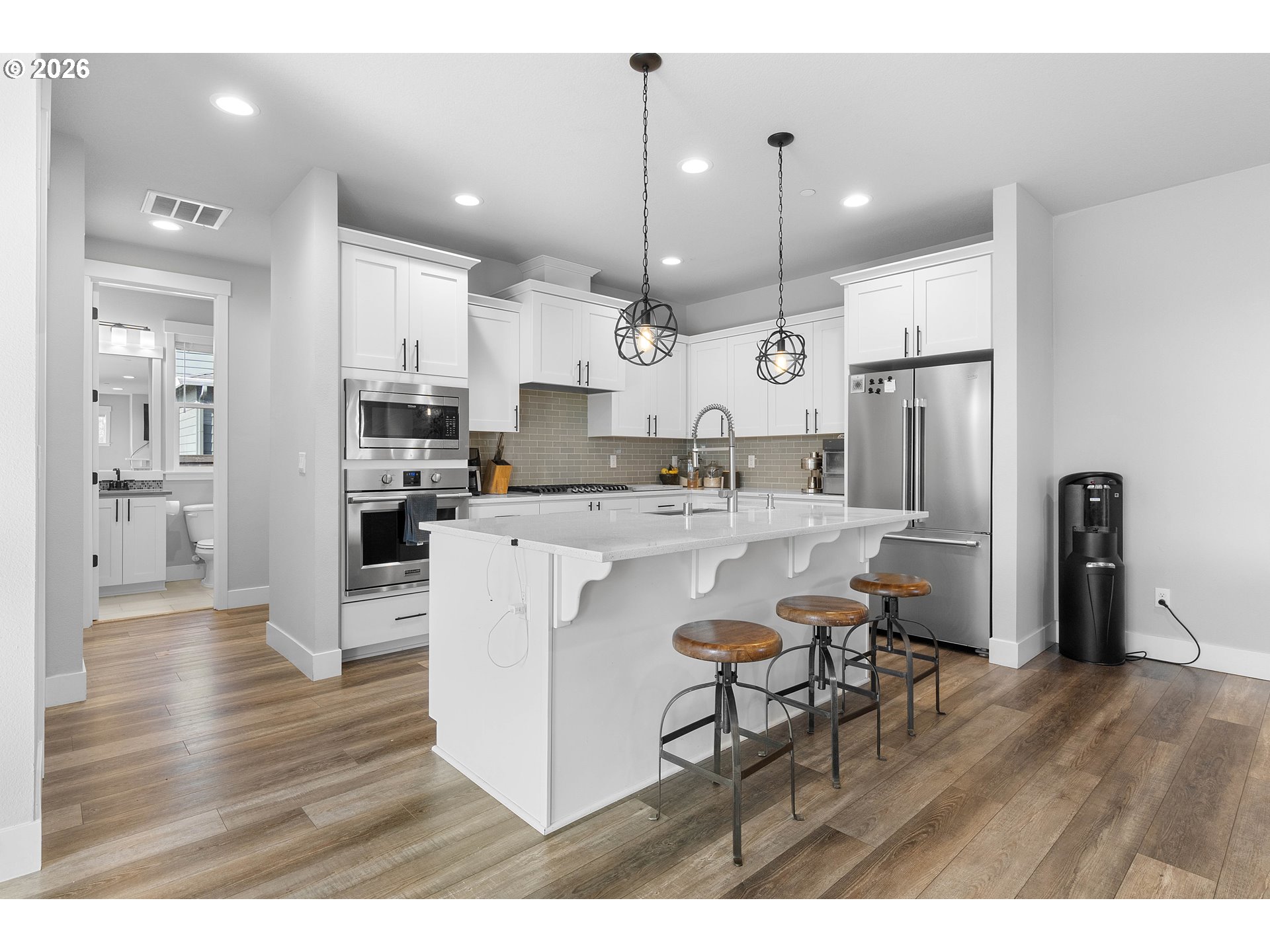 5788 North 86th Circle Camas, WA 98607 - Photo 6 of 26 a kitchen with stainless steel appliances kitchen island granite countertop a refrigerator a stove a sink a oven and a dining table with wooden floor