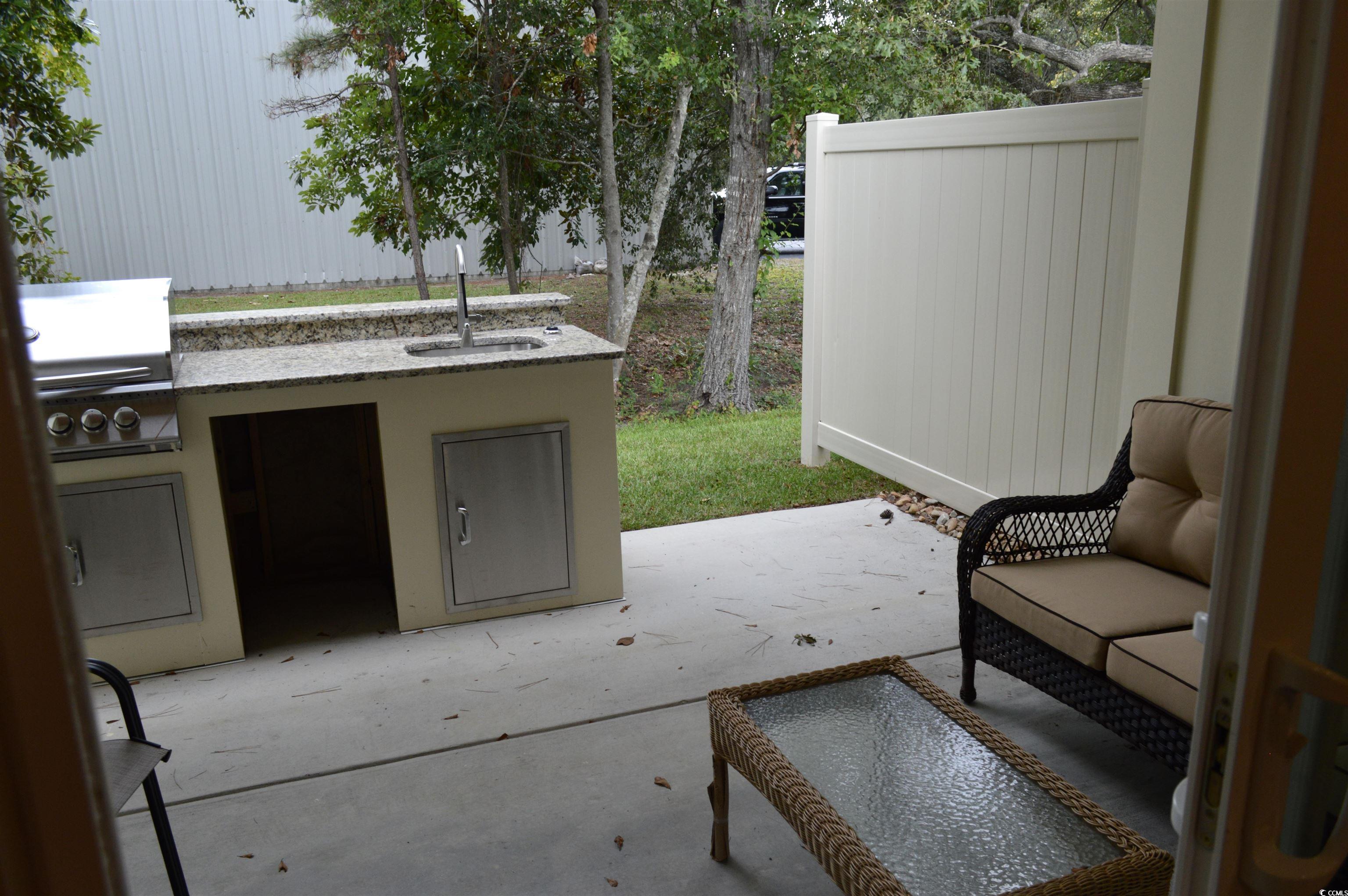 151 Hallandale Lane, Unit LEFT Murrells Inlet, SC 29576 - Photo 10 of 21 View of patio featuring area for grilling, a sink, fence, and exterior kitchen