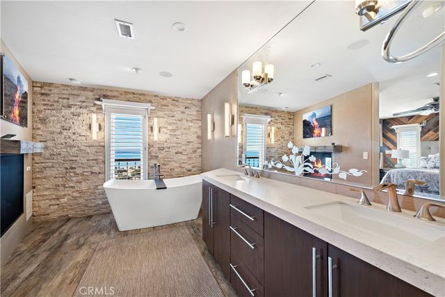 a bathroom with a sink double vanity granite tub shower and mirror