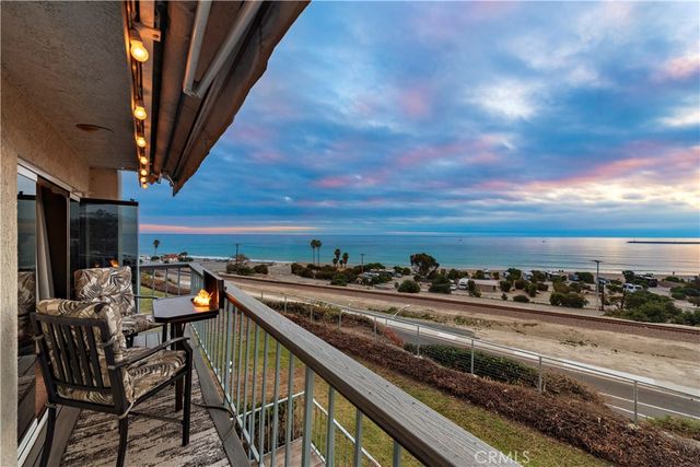 a view of a balcony with chairs and wooden fence