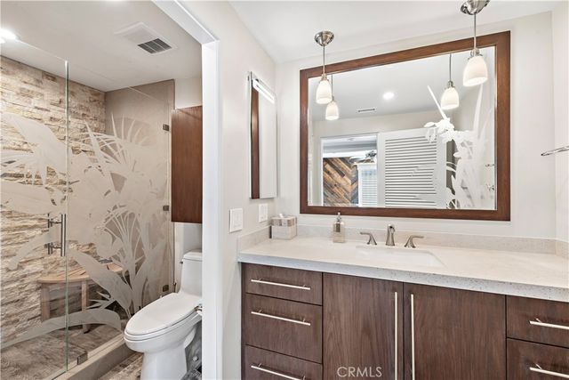 a bathroom with a sink vanity mirror and toilet