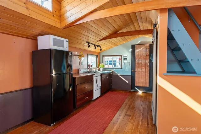 a kitchen view with wooden floor and electronic appliances