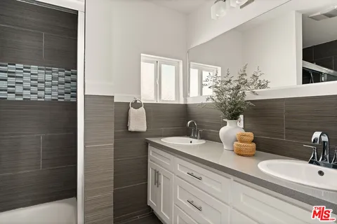 a bathroom with a double vanity sink and a mirror