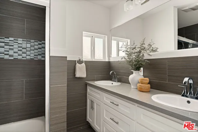 a bathroom with a double vanity sink and a mirror