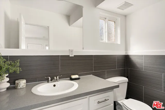 a bathroom with a sink toilet and mirror