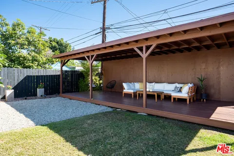a view of a backyard with a patio outdoor dining space and trees in the background