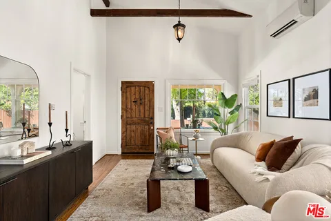 a living room with furniture kitchen view and large window