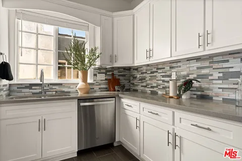 a kitchen with white cabinets and a sink