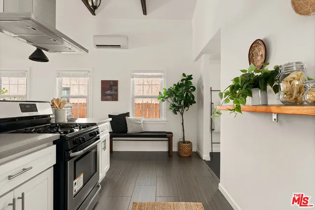 a kitchen with stainless steel appliances a stove a chimney a sink and cabinets