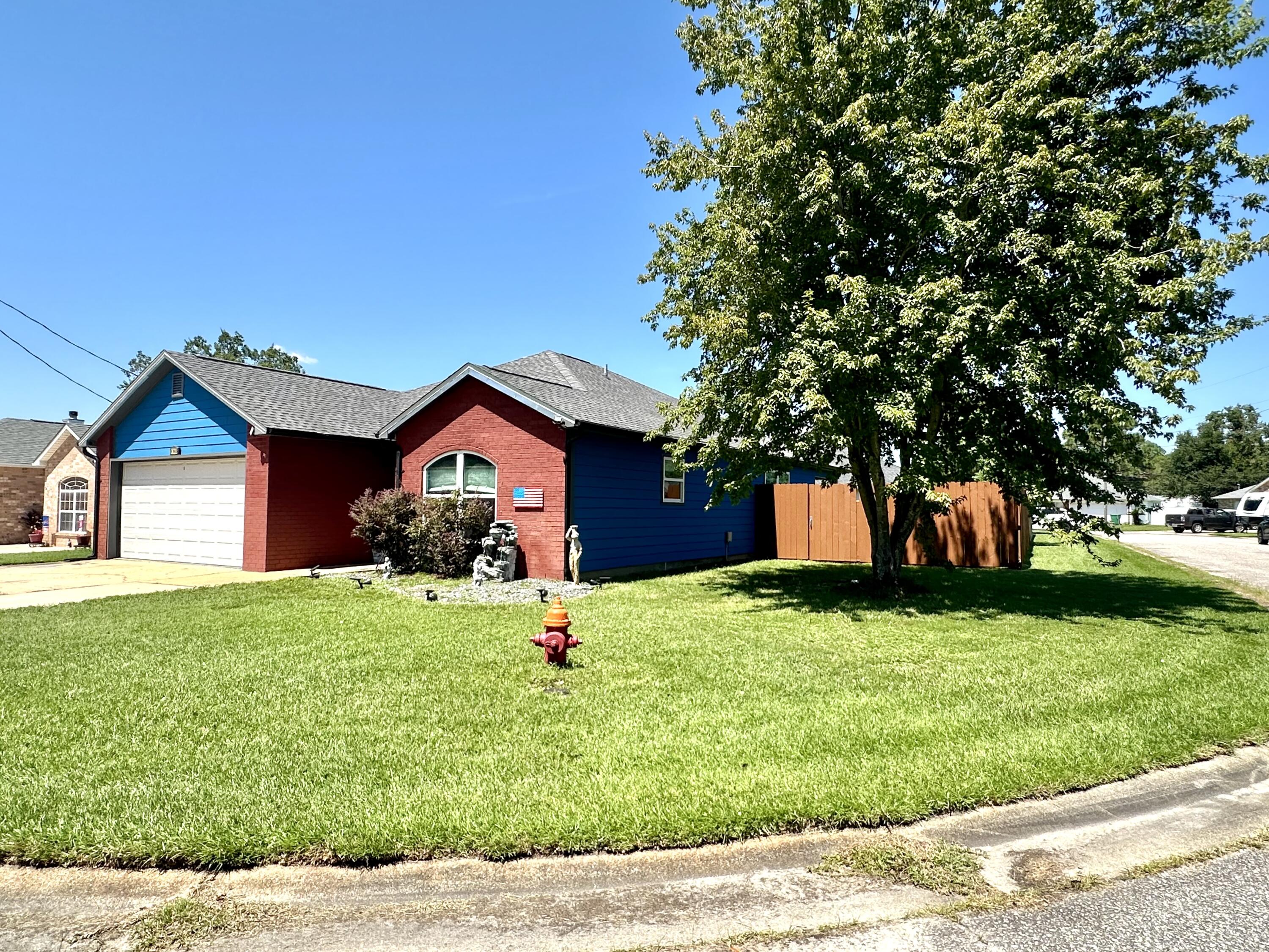 1765 Old Ranch Road Fort Walton Beach, FL 32547 - Photo 2 of 31 a front view of a house with a yard and garage