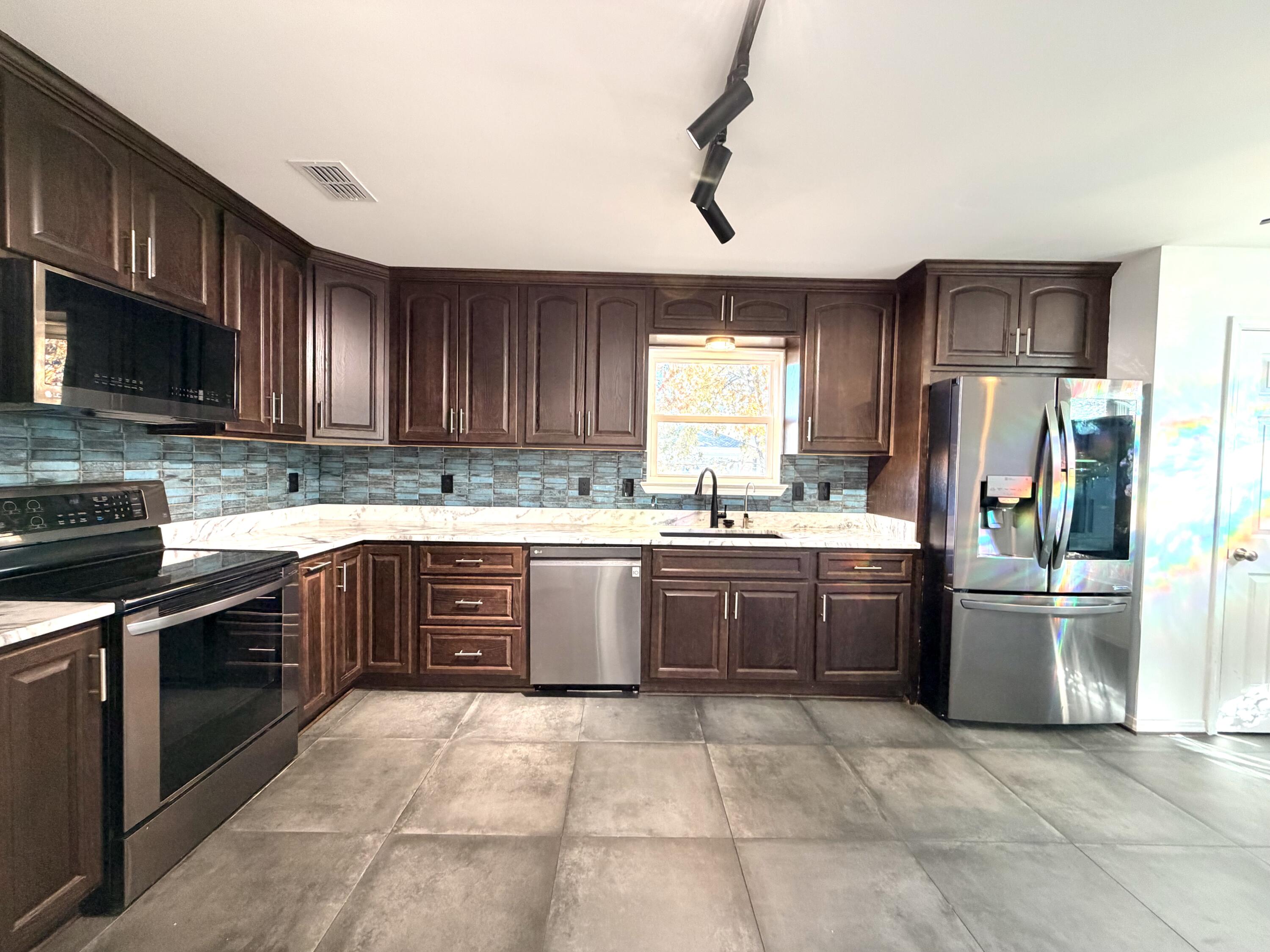 1765 Old Ranch Road Fort Walton Beach, FL 32547 - Photo 5 of 31 a kitchen with stainless steel appliances granite countertop a refrigerator stove top oven a sink and dishwasher