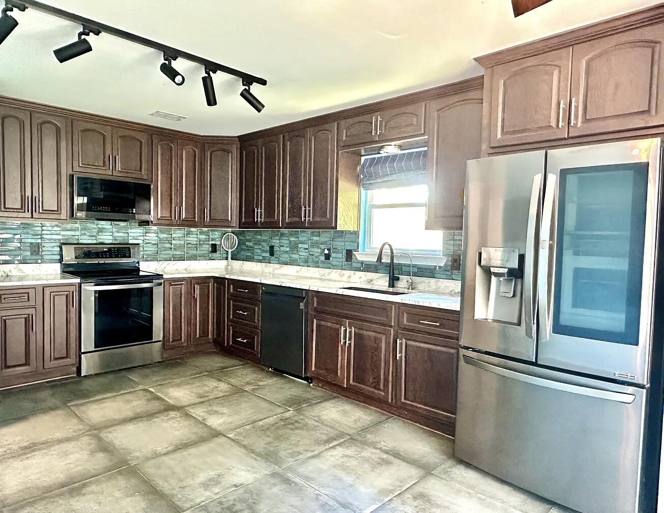 1765 Old Ranch Road Fort Walton Beach, FL 32547 - Photo 6 of 31 a kitchen with stainless steel appliances granite countertop a stove top oven a sink and a refrigerator