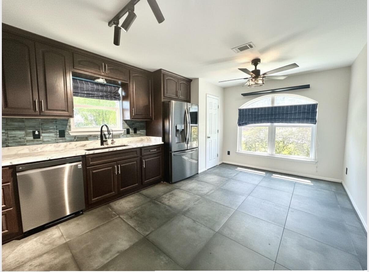 1765 Old Ranch Road Fort Walton Beach, FL 32547 - Photo 7 of 31 a kitchen with stainless steel appliances a sink a stove a refrigerator cabinets and a window