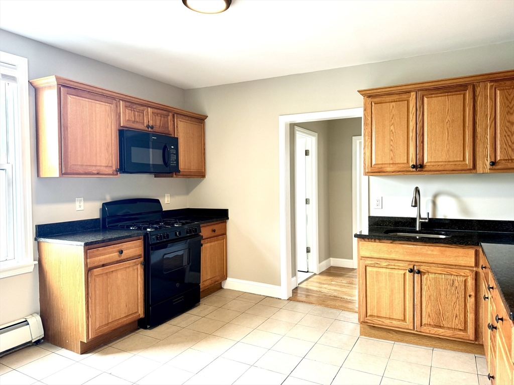a kitchen with stainless steel appliances granite countertop a stove sink and cabinets