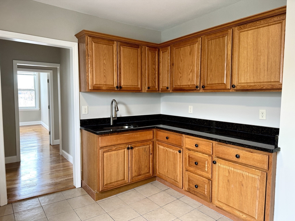56 Estes Street, Unit 5 Lynn, MA 01902 - Photo 2 of 11 a kitchen with granite countertop cabinets and sink