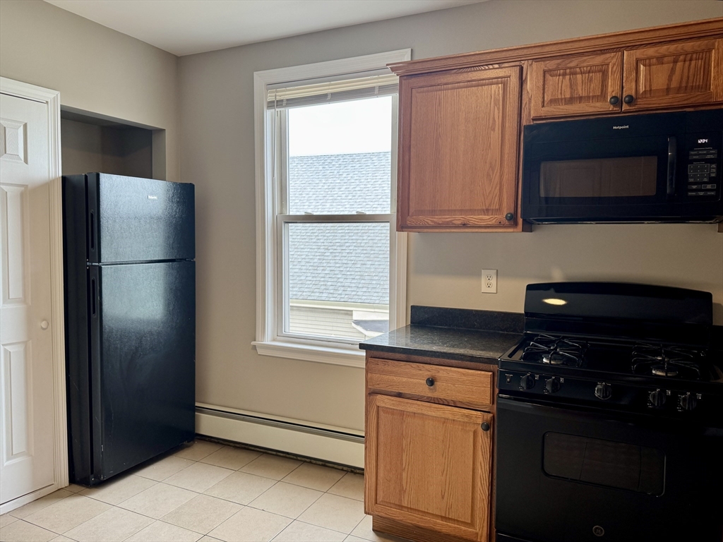 56 Estes Street, Unit 5 Lynn, MA 01902 - Photo 3 of 11 a kitchen with a refrigerator and a stove