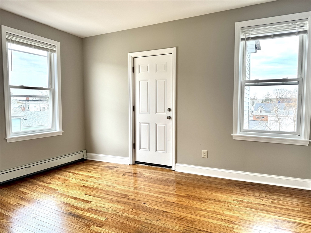 56 Estes Street, Unit 5 Lynn, MA 01902 - Photo 4 of 11 a view of empty room with window and wooden floor