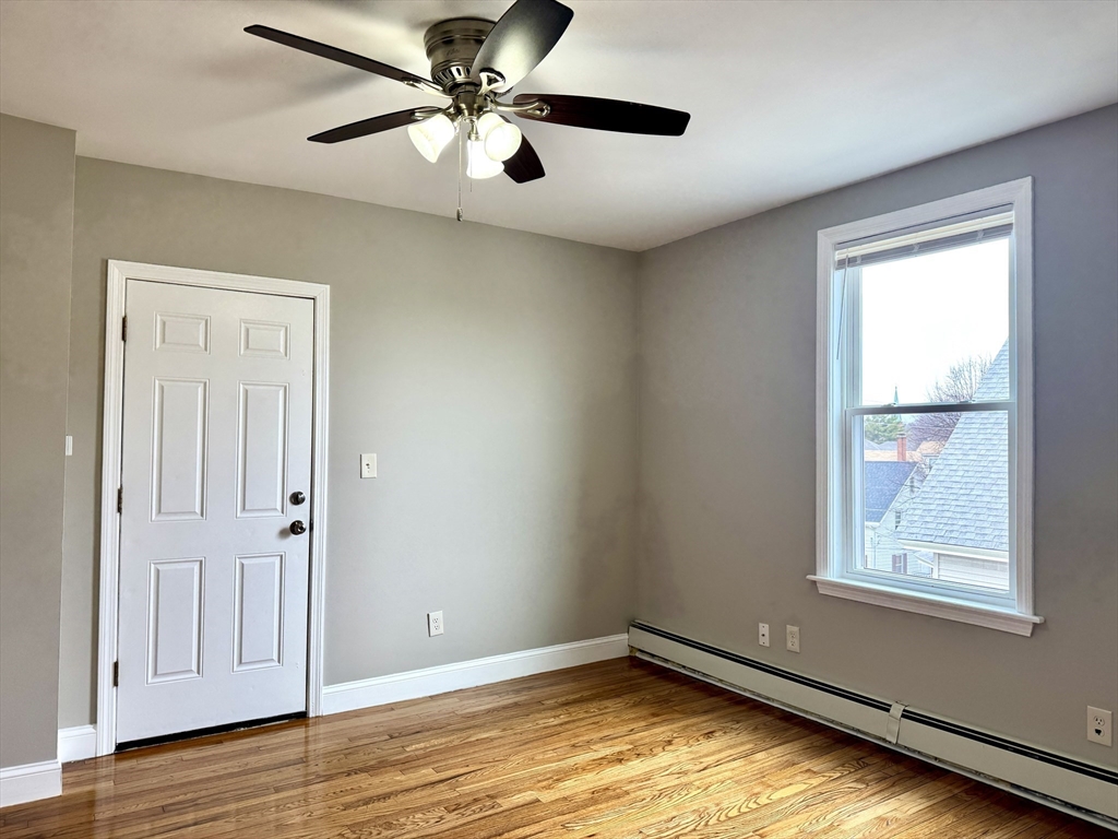 56 Estes Street, Unit 5 Lynn, MA 01902 - Photo 10 of 11 wooden floor in an empty room with a window