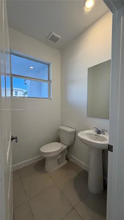 a bathroom with a sink a toilet and mirror