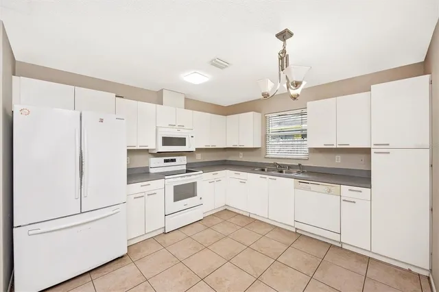 a kitchen with white cabinets and white appliances